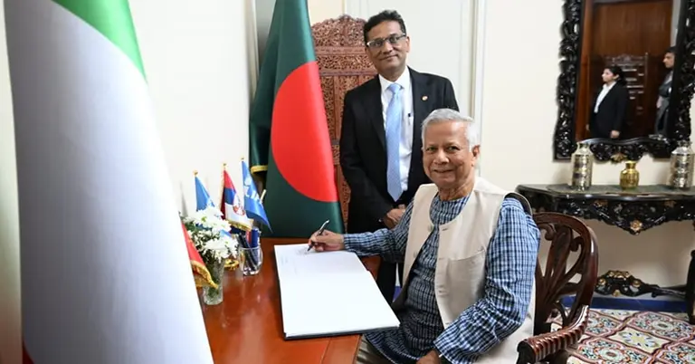 বাংলাদেশ হাউস পরিদর্শন শেষে বইয়ে স্বাক্ষর করছেন প্রধান উপদেষ্টা
